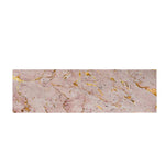 Cette image montre une texture de surface de pierre rose parsemée de veines dorées, créant un motif décoratif et élégant.