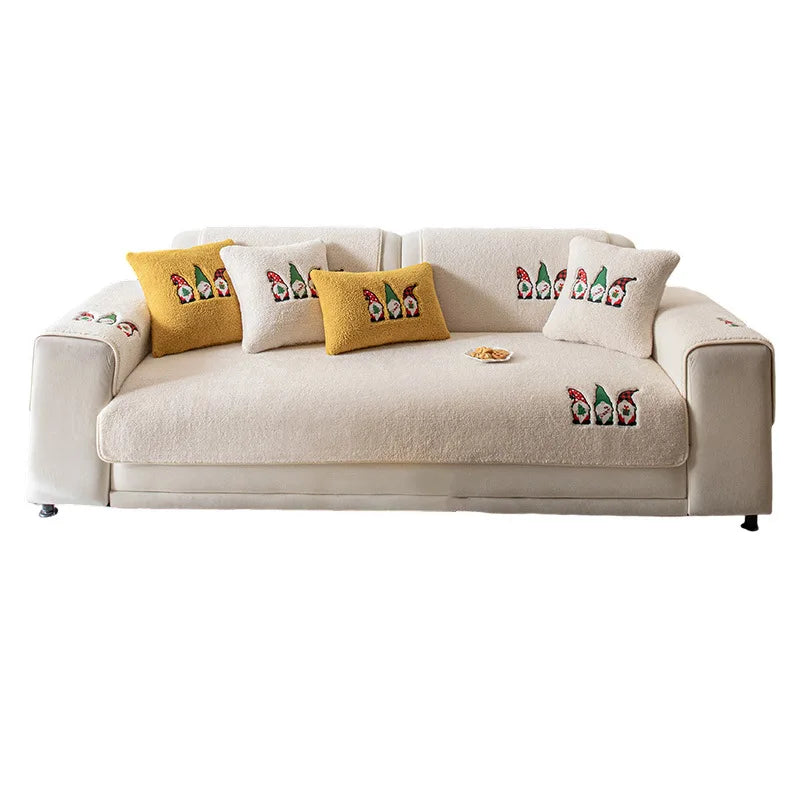 Un canapé beige confortable orné de coussins décoratifs aux motifs d'elfes colorés, créant une ambiance chaleureuse et festive.