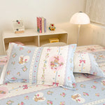 Une chambre d'enfant aux tons pastels, avec des motifs de lapins et de fleurs sur les coussins et les couvertures.