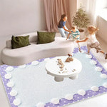 Deux enfants jouent sur un tapis violet décoré de nuages blancs dans un salon lumineux, avec un grand canapé blanc et des coussins verts.