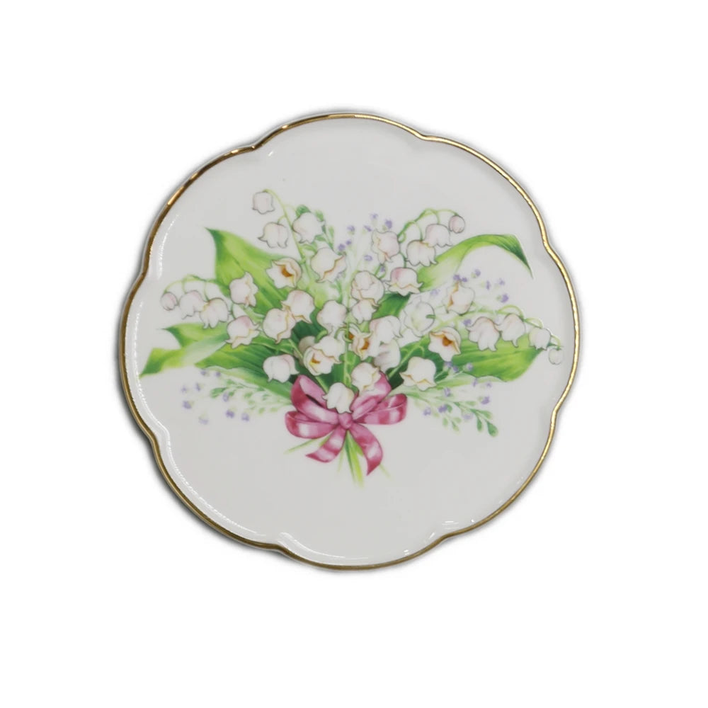 Magnifique bouquet de fleurs de muguet sur fond blanc avec un joli ruban rose.