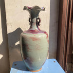 Vase décoratif aux couleurs pastel avec un design unique et texturé, créant une pièce d'intérieur élégante et artistique.