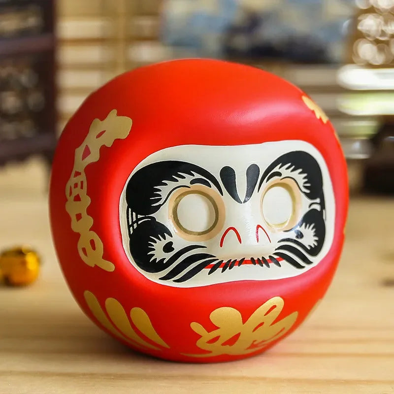 statuette japonaise daruma rouge blanche visage sourire yeux grands ouverts motifs dorés traditionnels décoration