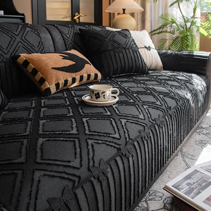 Un canapé confortable et élégant avec des coussins noirs et blancs, entouré d'une décoration végétale qui apporte une touche naturelle à l'ensemble.