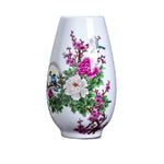 Vase en porcelaine blanc décoré de fleurs de pivoines et de prunus, avec des oiseaux en vol, créant une scène florale élégante et raffinée.