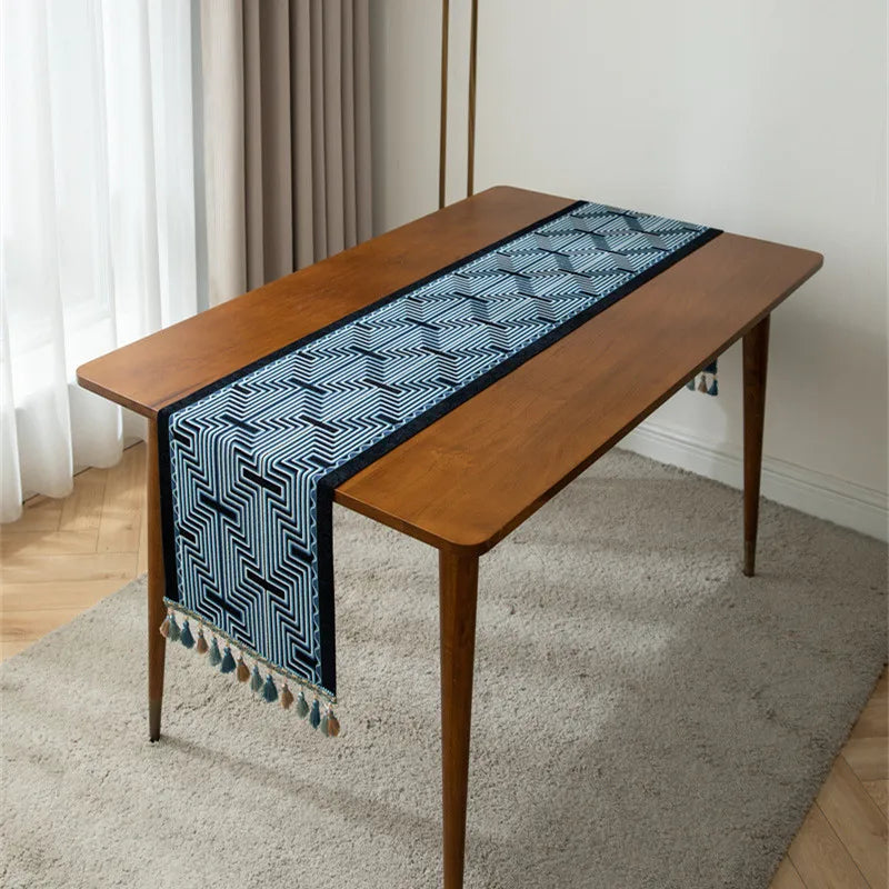 Une élégante table en bois avec un chemin de table bleu et blanc aux motifs géométriques.