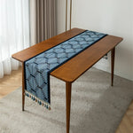 Une élégante table en bois avec un chemin de table bleu et blanc aux motifs géométriques.