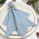 Un arrangement de table élégant avec une serviette bleue en textile entourée d'éléments décoratifs naturels.