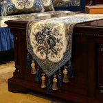 Tapis de table en tissus ornementés de motifs floraux avec des pompons et des glands décoratifs.