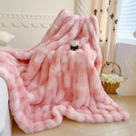 Une couverture en fausse fourrure rose fournit une chaleur et un confort douillet dans cette chambre élégante.