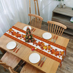 Une table avec des décorations d'automne, des bougies, des assiettes, des couverts et un petit arbre de Noël orné.