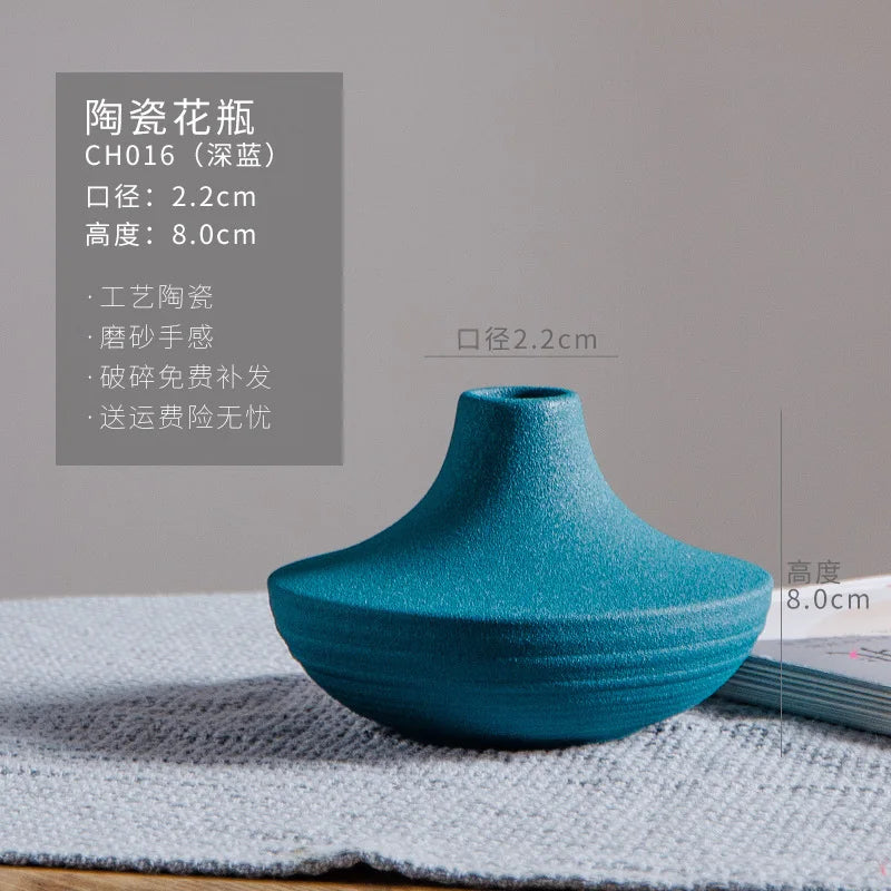 Vase en céramique bleu turquoise avec des dimensions de 2,2 cm de diamètre et 8 cm de hauteur, présentant une texture de surface irrégulière et un design épuré.