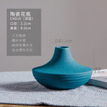 Vase en céramique bleu turquoise avec des dimensions de 2,2 cm de diamètre et 8 cm de hauteur, présentant une texture de surface irrégulière et un design épuré.