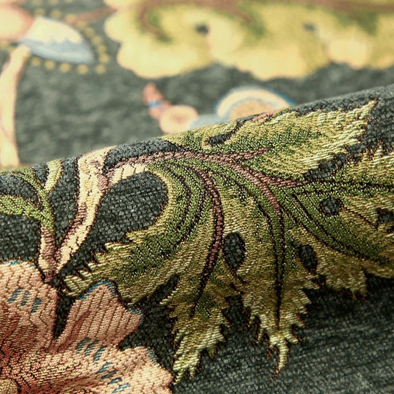 Gros plan sur un tissu motif tropical avec des feuilles stylisées en vert, marron et bleu.