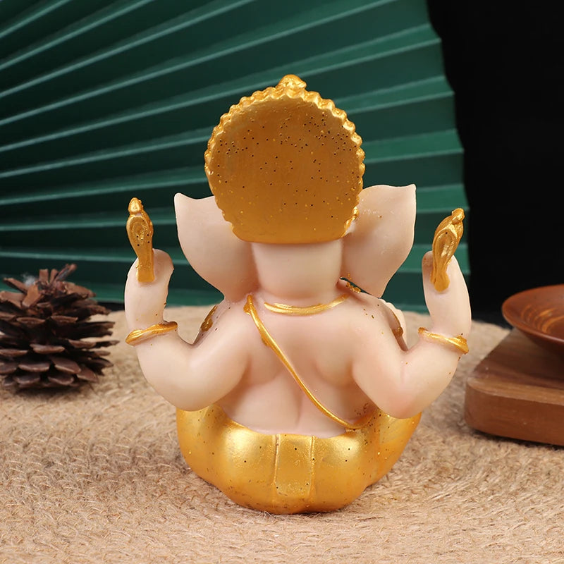 statue ganesha or beige details sculptés traditionnel religieux assiette bois cône pin feuilles vertes