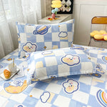 Un ensemble de literie avec un motif de personnages joyeux et d'éléments célestes, créant une ambiance ludique et apaisante pour la chambre d'un enfant.