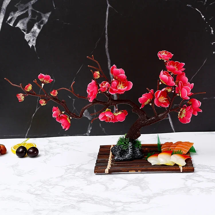 composition florale artificielle fleurs cerisier rouge rose vert branches noires pierre décorative moderne intérieur