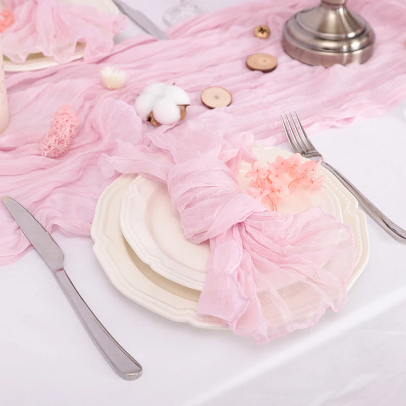 Une table de fête élégante avec des assiettes blanches, une serviette en tissu rose pastel, et une belle fleur en guise de décoration.