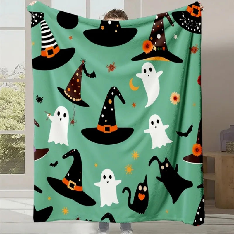 Couverture d'Halloween avec des motifs de chapeaux de sorcière, de fantômes et de chats noirs sur un fond vert menthe.