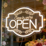 enseigne lumineuse néon ouverte come in blanc doré vintage transparent cadre feuilles stylisées porte