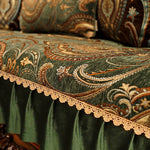 Coussin décoratif avec un motif en paisley de couleurs riches et un bord orné de dentelle dorée, créant une ambiance luxueuse et élégante dans un espace d'intérieur.