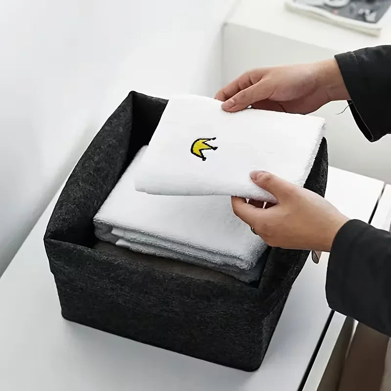 boîte rangement tissu veloutée gris clair foncée moderne pliable articles divers serviettes blanches broderie