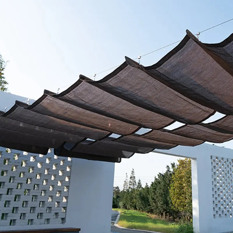 Voile d'ombrage vague HDPE beige protégeant une pergola