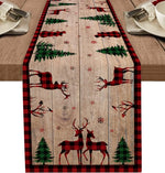 Cette élégante décoration de table de Noël présente un motif forestier rustique sur un fond de bois clair, avec des silhouettes de cerfs rouges et noirs sur un motif à carreaux rouges et noirs.