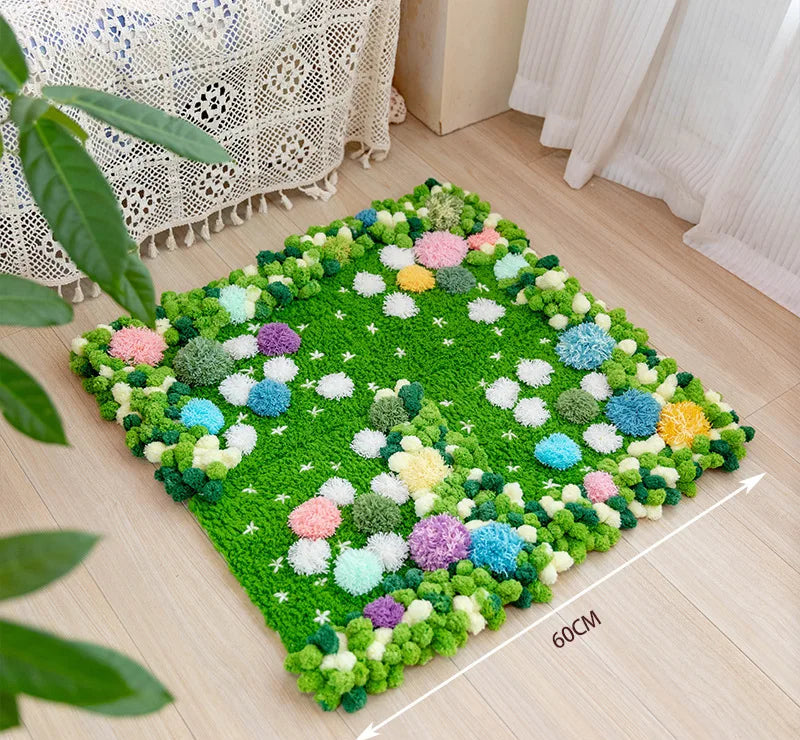 Tapis de sol fleuri et moelleux avec des pompons de différentes couleurs sur un sol en bois.