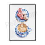 Une tasse de café chaud avec un motif art latte et une assiette de délicieux macarons colorés posés sur un fond blanc.