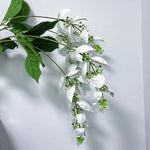 branche artificielle fleurs naturelles extérieur accrochées blanc vert feuilles larges minimaliste