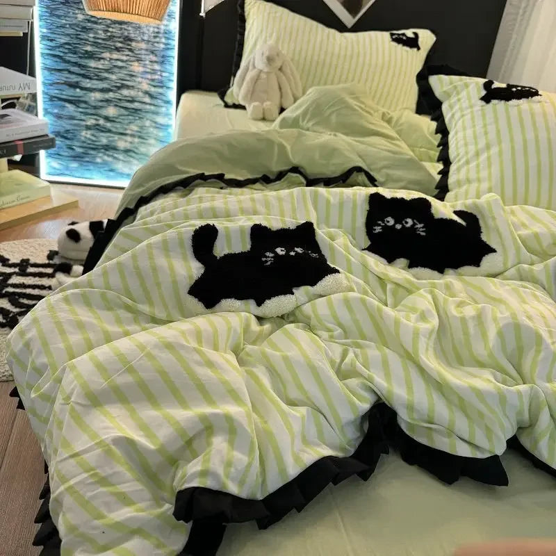 Détail de la broderie de chat rose sur la housse de couette rayée