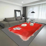 Cette image montre un intérieur minimaliste avec un canapé gris, des lampes design et un tapis rouge dans un salon lumineux.