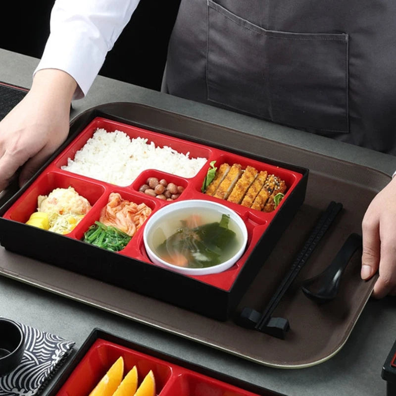 boîte repas traditionnelle japonaise rouge noire texture bois compartiments multiples riz viandes légumes poisson