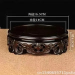 support circulaire bois sculpté artisanal traditionnel marron foncé détails complexes vase plantes décoration maison