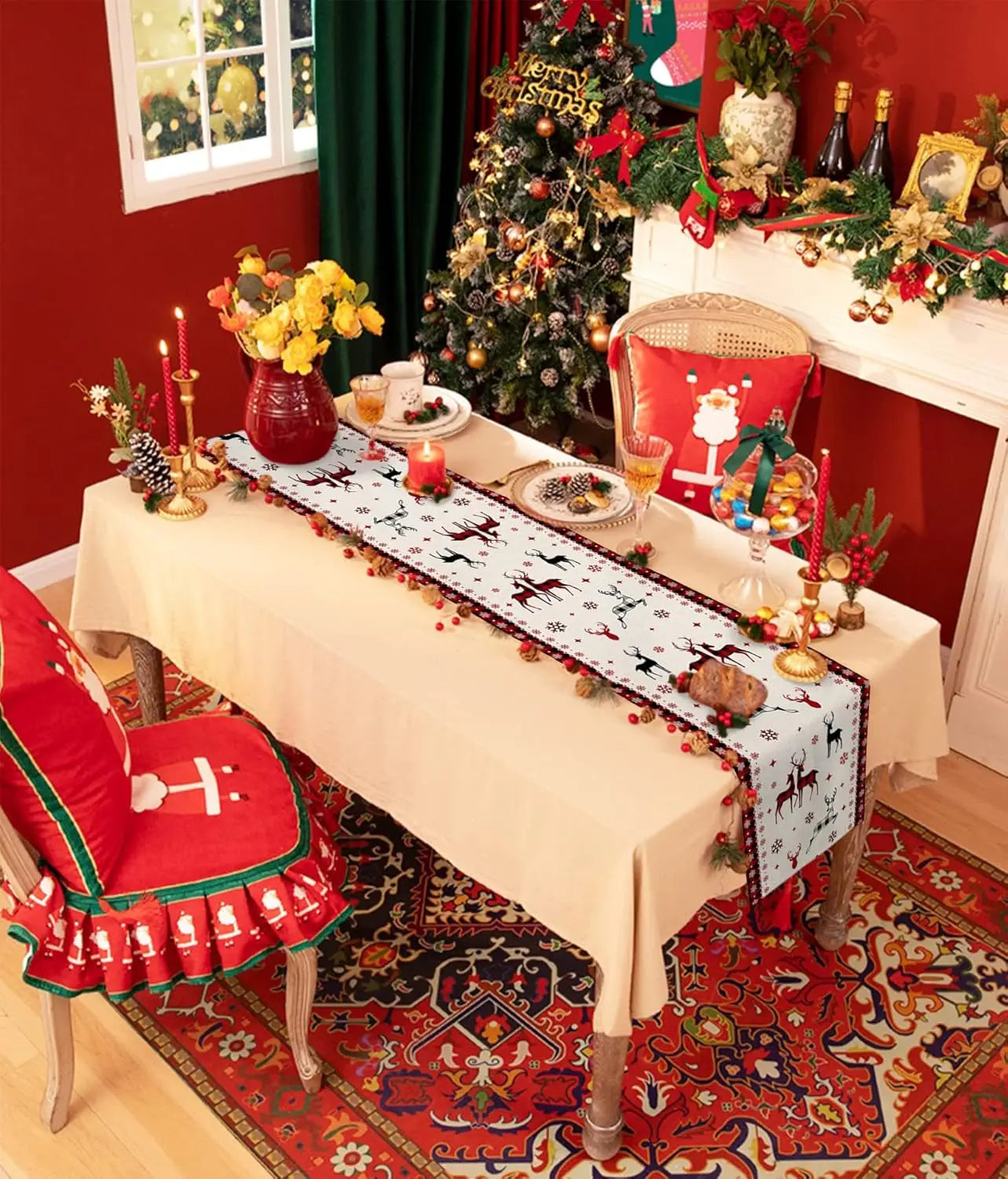 Décor de Noël festif avec un sapin décoré, des fleurs, des bougies, et une table recouverte d'un chemin de table motif renne sur fond blanc.