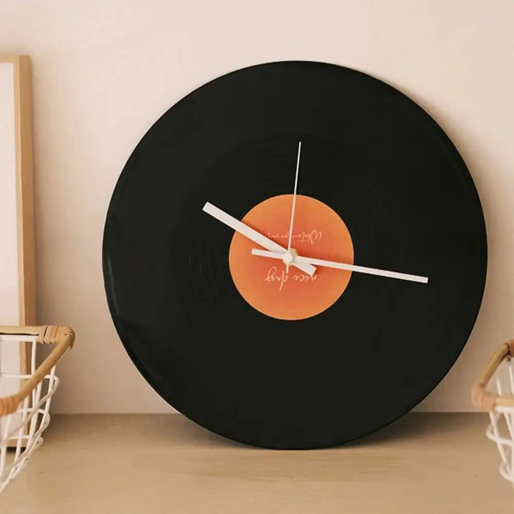 horloge murale vintage disque vinyle noir orange aiguilles blanches support métallique minimaliste moderne decoration