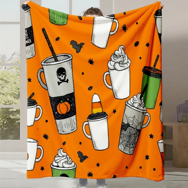 Couverture orange avec motifs d'Halloween incluant des tasses effrayantes, des araignées et des éléments traditionnels de cette fête.