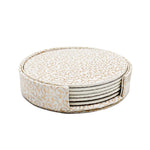 Une pile de sous-verres décoratifs avec des motifs dorés sur fond blanc, offrant une touche élégante et ornementale à la décoration d'intérieur.
