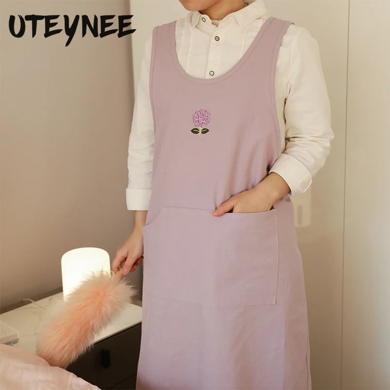 Tablier de cuisine femme en coton brodé bleu montrant les poches pratiques