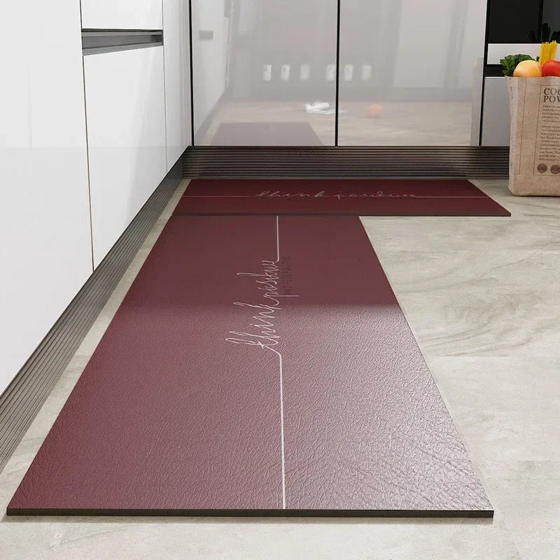 Tapis d'entrée élégant et minimaliste avec inscription en cursive sur fond bordeaux.