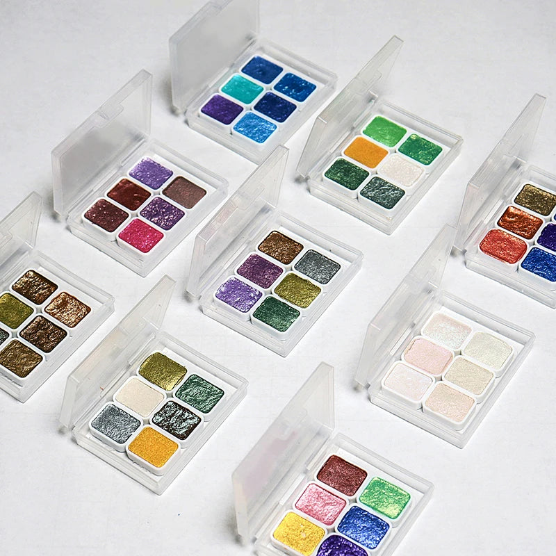 peintures aquarelle palette compacte bleu vert violet rose beige jaune blanc texture granuleuse opaques