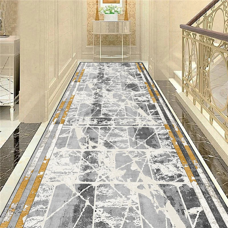 Tapis de couloir en marbre gris avec des bandes dorées, créant un motif élégant et luxueux pour l'entrée de la maison.