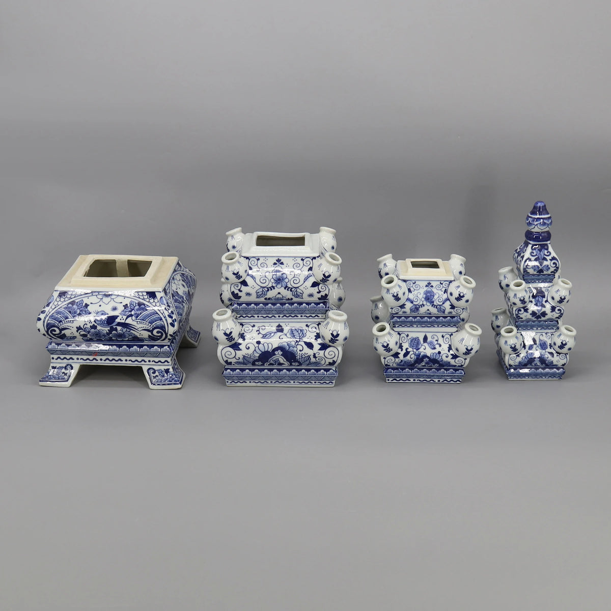 Une collection de vases et jardinières décoratifs en céramique bleu et blanc, ornés de motifs floraux et de formes géométriques élégantes.