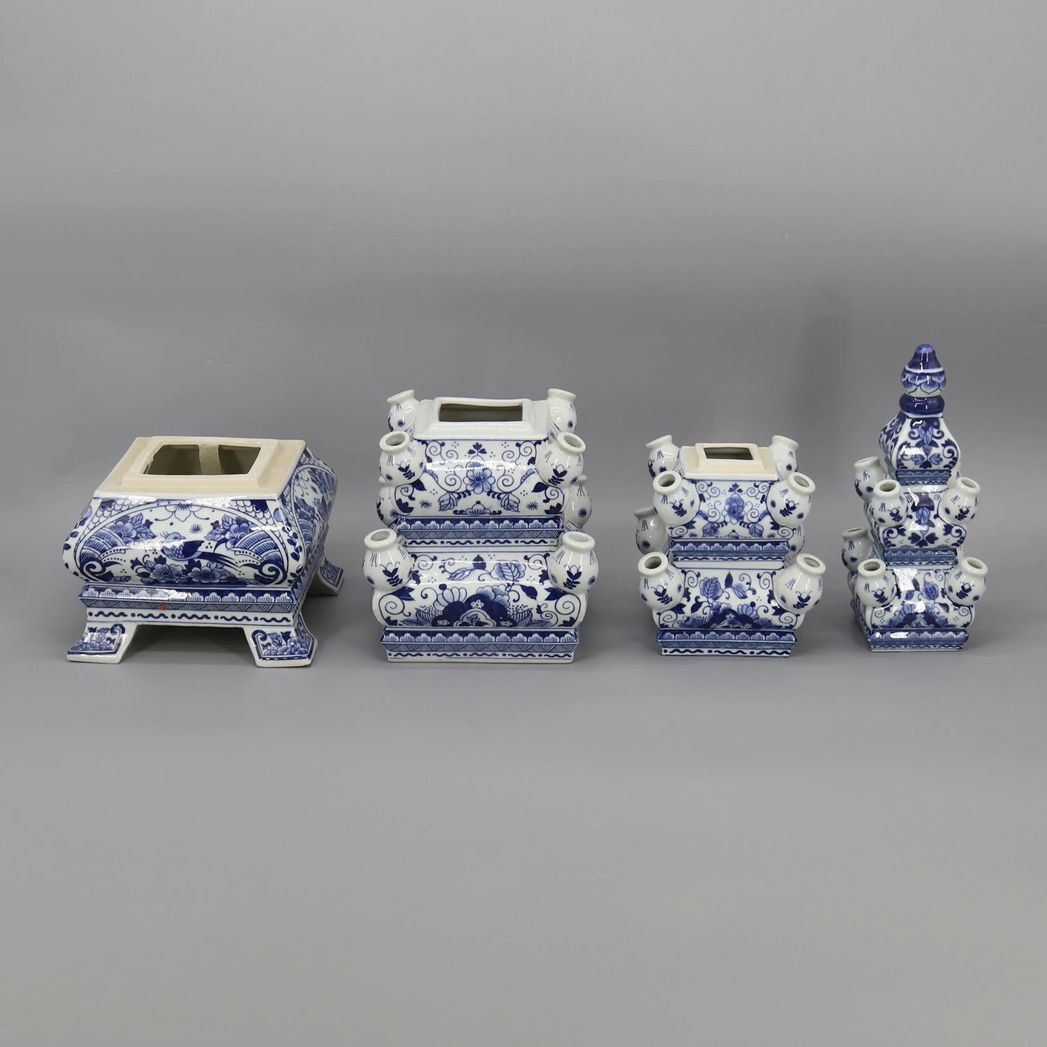 Une collection de vases et jardinières décoratifs en céramique bleu et blanc, ornés de motifs floraux et de formes géométriques élégantes.
