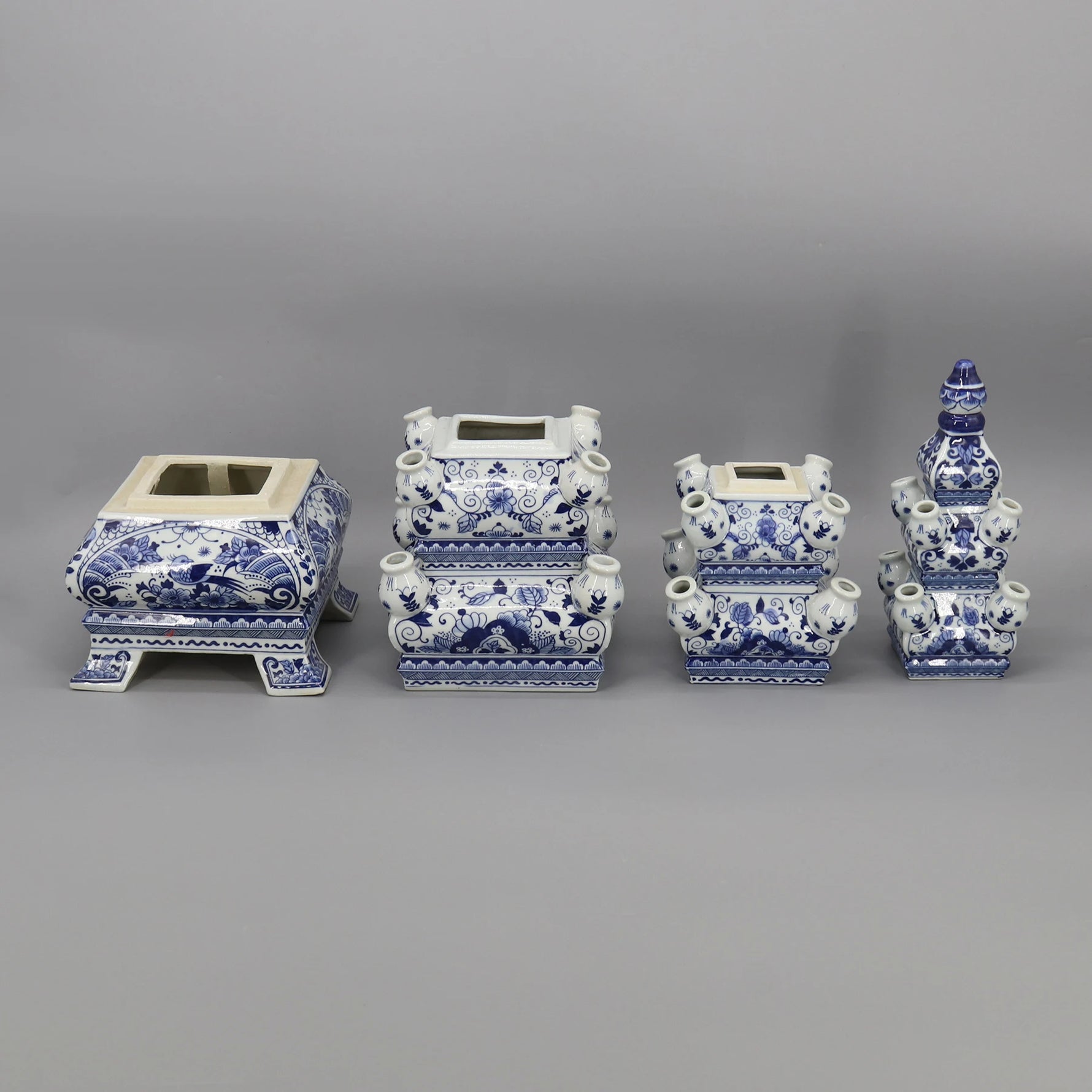 Une collection de vases et jardinières décoratifs en céramique bleu et blanc, ornés de motifs floraux et de formes géométriques élégantes.