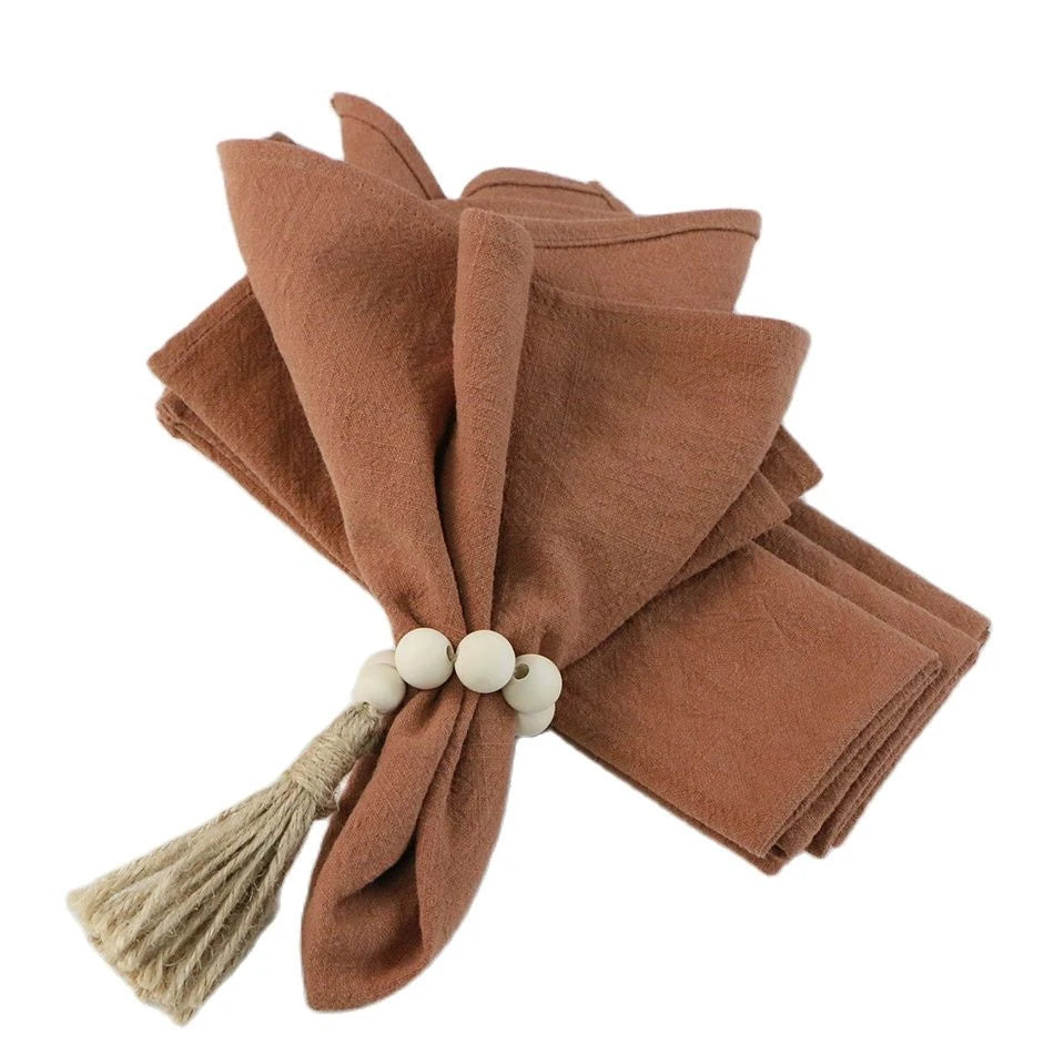 serviettes tissu pliées rustique bohème minimaliste liens anneaux couleurs beige rose vert bleu gris