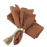 serviettes tissu pliées rustique bohème minimaliste liens anneaux couleurs beige rose vert bleu gris
