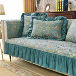 Une élégante causeuse vintage recouverte de jolis motifs floraux turquoise sur fond blanc, soulignée de volants qui habille avec raffinement cet espace harmonieux.