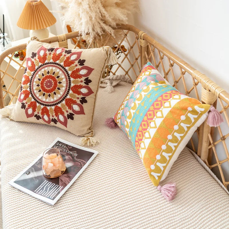 L'image montre un coin cocooning avec un fauteuil en rotin et des coussins colorés et motifs ethniques, ainsi qu'une lampe orange et des magazines posés sur un tapis beige, créant une ambiance chaleureuse et accueillante.